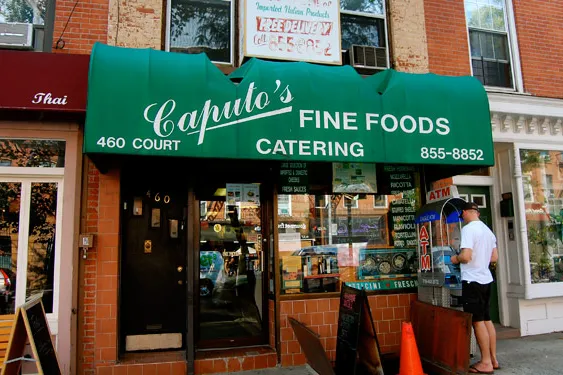 Caputo's fine foods, with a green overhang, is a great option to shop for groceries if you're staying in a Carroll Gardens apartment rental
